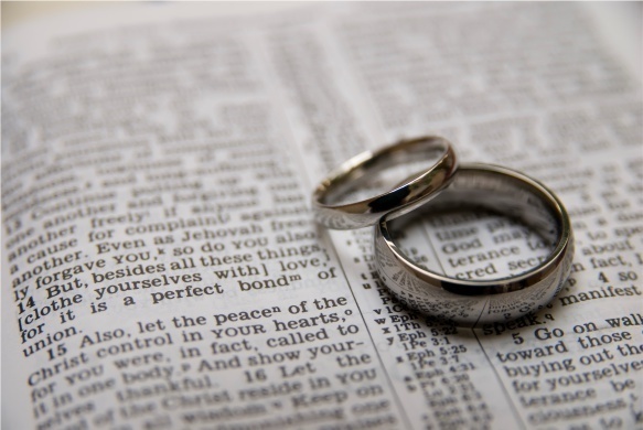 two wedding rings on a page of the Bible